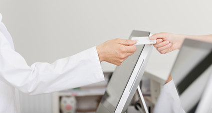 Dental receptionist and patient at payment desk - Dental Insurance